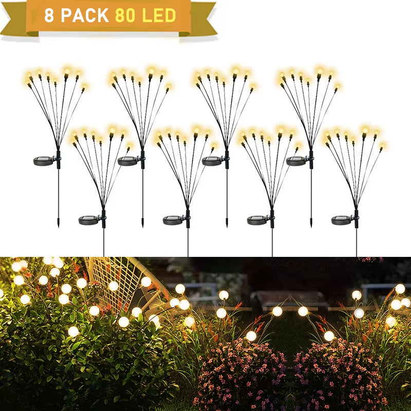 Set of eight solar firefly lights with yellow LED bulbs, shown in daylight and at night in a garden